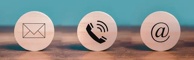 3 images on wooden discs of an envelope, a telephone & an @ symbol